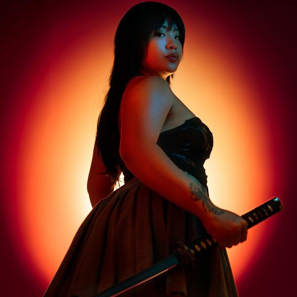 Silhouette of a woman in a strong yoga warrior pose at sunset.